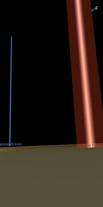 Phone screenshot at ground level: a thin blue Tacoma tower and a wide red glowing Seattle tower
